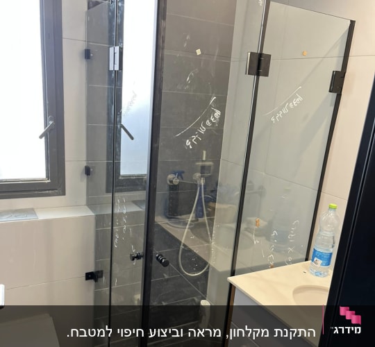 מקלחון זכוכית עם דלתות שקופות ומסגרת שחורה